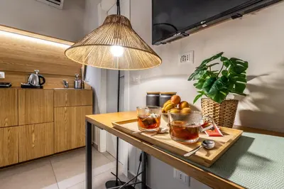 a kitchen with a table with two glasses and a lamp at Dafne room Un'oasi romana per coppie in Rome