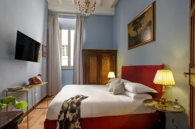 a bedroom with a bed and a table and a television at Daplace - Villetta Sant'Onofrio in Rome
