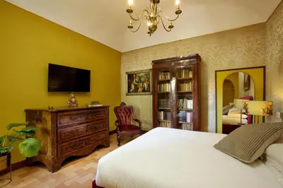 a bedroom with a bed and a dresser and a tv at Daplace - Villetta Sant'Onofrio in Rome