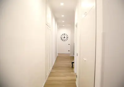 a hallway with white walls and a clock on the wall at Domus Olympia in Rome