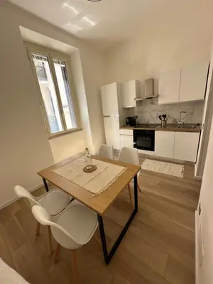 a kitchen with a wooden table and chairs in a room at Domus Olympia in Rome