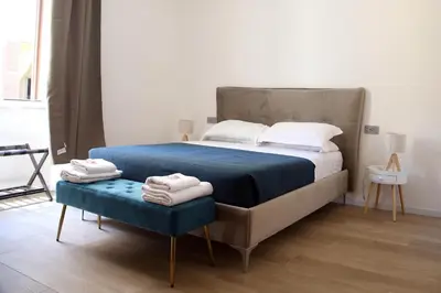 a bedroom with a bed and a blue ottoman at Domus Olympia in Rome