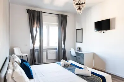 a bedroom with a bed and a desk and a window at Pascal boutique rooms in Rome