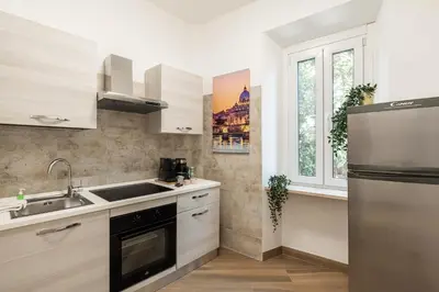 a kitchen with a sink and a refrigerator at Alba Vatican Apartment in Rome