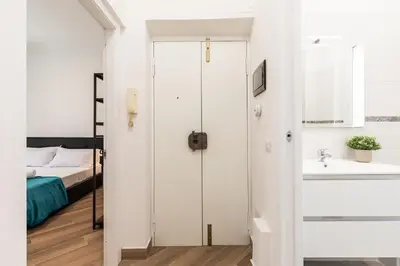 a bedroom with a bed and a bathroom with a sink at Alba Vatican Apartment in Rome