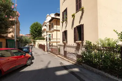 a red car parked on a street next to a building at Alba Vatican Apartment in Rome