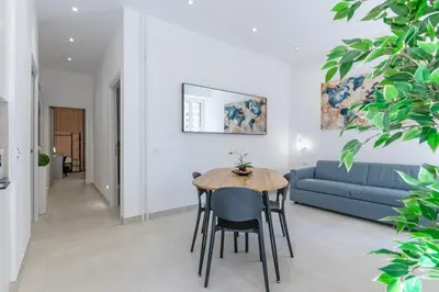 a living room with a table and a blue couch at Roma apartment near to Colosseum Re-House in Rome
