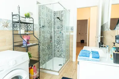 a bathroom with a shower and a washing machine at Rea house Colli Albani - B&Brother's rome in Rome