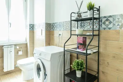 a bathroom with a washer and dryer in it at Rea house Colli Albani - B&Brother's rome in Rome