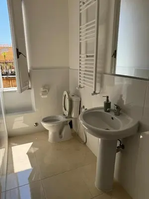 a white bathroom with a toilet and a sink at Raynova in Rome