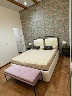 a bedroom with a large bed with a floral wallpaper at Carrozze apartment in Rome