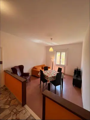 a living room with a table and chairs and a bed at Alla Pineta in Rome