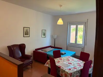 a living room with a table and a bed at Alla Pineta in Rome