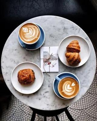 a table with plates of pastries and cups of coffee at I Quattro Elementi Roma in Rome