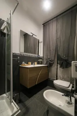 a bathroom with a sink and a toilet and a mirror at I Quattro Elementi Roma in Rome