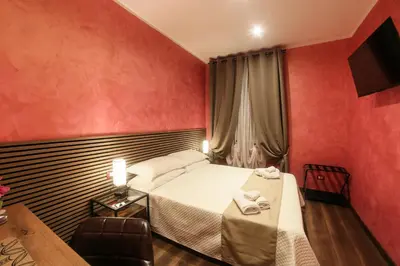 a hotel room with a bed and a chair at I Quattro Elementi Roma in Rome