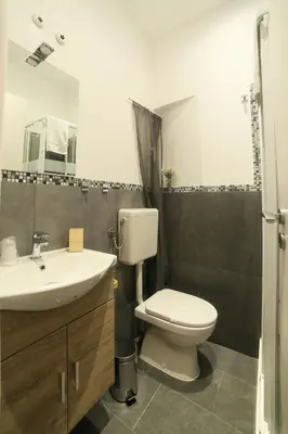 a bathroom with a toilet and a sink and a mirror at I Quattro Elementi Roma in Rome