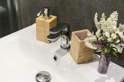 a sink with a faucet and a vase with flowers at I Quattro Elementi Roma in Rome