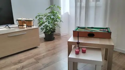a living room with a table with a pool cue at A Casa di Cri in Rome