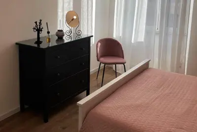 a bedroom with a bed and a dresser and a chair at A Casa di Cri in Rome