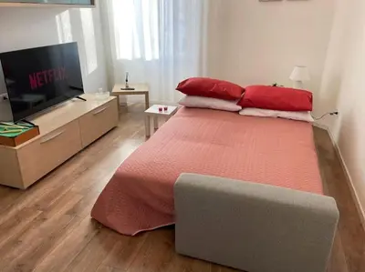 a bedroom with a large bed with red pillows and a television at A Casa di Cri in Rome