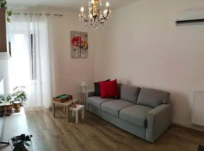a living room with a couch and a chandelier at A Casa di Cri in Rome