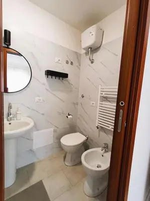 a white bathroom with a toilet and a sink at Pi gneto GH Locazione Turistica in Rome