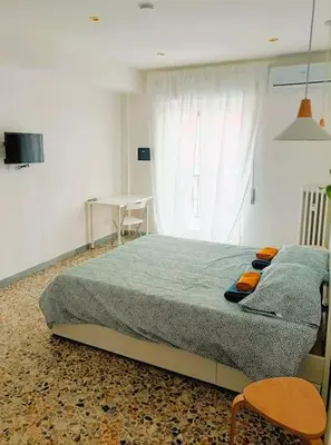 a bedroom with a bed and a table and a window at Pi gneto GH Locazione Turistica in Rome