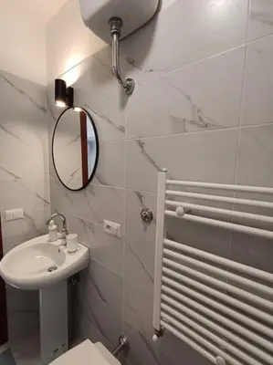 a bathroom with a sink and a mirror and a toilet at Pi gneto GH Locazione Turistica in Rome