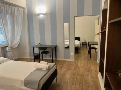 a bedroom with a bed and a table and a mirror at PiazzaBolognaStay in Rome
