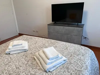 a bedroom with two towels on a bed with a television at Dasy Apartment - San Paolo in Rome