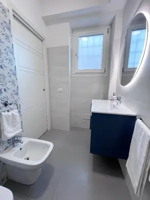 a white bathroom with a sink and a mirror at Dasy Apartment - San Paolo in Rome