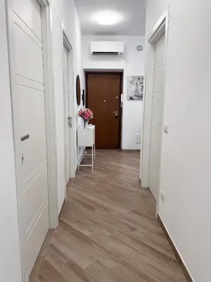 a hallway with white doors and wooden floors at Dasy Apartment - San Paolo in Rome