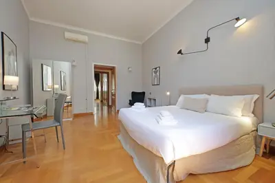 a bedroom with a large white bed and a desk at Appartamento 