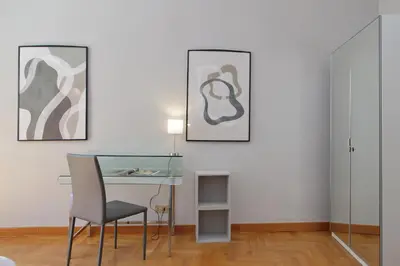 a dining room with a glass table and three paintings at Appartamento 