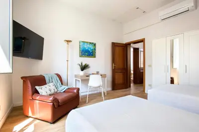 a bedroom with a bed and a chair and a desk at Casa Marchese Lucia in Rome