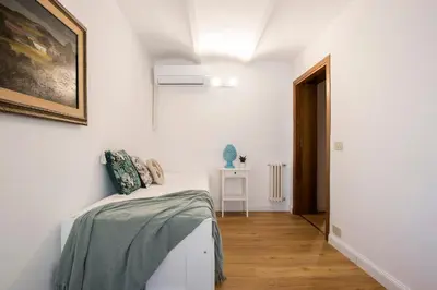 a white room with a bed and a painting on the wall at Casa Marchese Lucia in Rome