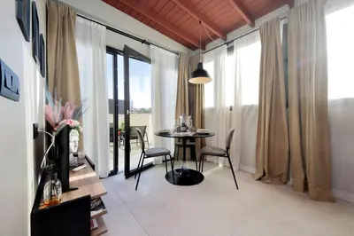a dining room with a table and chairs and windows at 100m dal Vaticano Oasi Luxury 2 Terraces in Rome