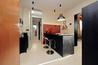 a kitchen with a black counter and a bar at 100m dal Vaticano Oasi Luxury 2 Terraces in Rome