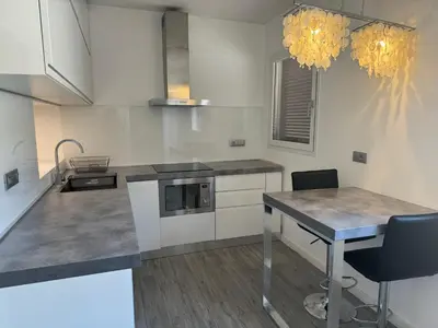 a kitchen with white cabinets and a table with chairs at Mercede Apartment - Spanish Steps in Rome