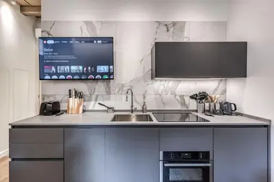 a kitchen with a sink and a tv on the wall at Piazza dei Renzi Trastevere building 4 bedroom with terrace in Rome