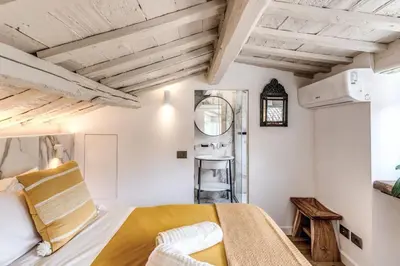 a bedroom with white walls and a bed with yellow sheets at Piazza dei Renzi Trastevere building 4 bedroom with terrace in Rome