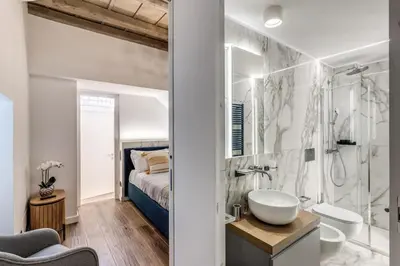 a bathroom with a sink and a shower and a bed at Piazza dei Renzi Trastevere building 4 bedroom with terrace in Rome