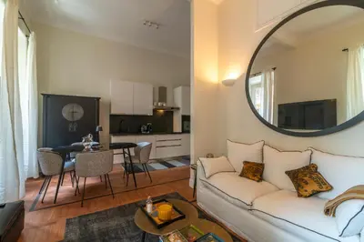 a living room with a white couch and a mirror at Villa Borghese Luxury Place in Rome