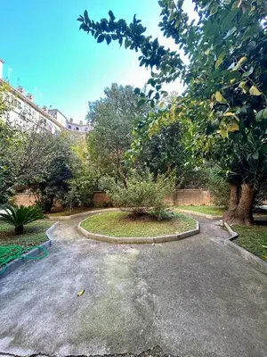 a garden with a circular driveway with a tree at D Guest House in Rome