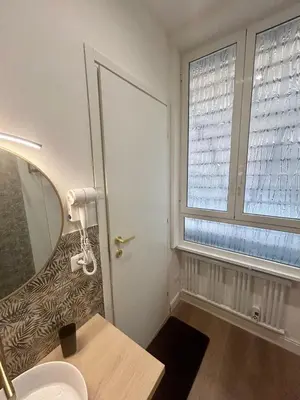 a bathroom with a door and a sink and a window at D Guest House in Rome
