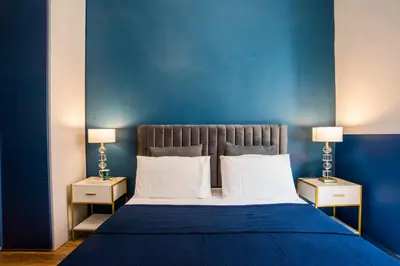 a blue bedroom with a large bed with two night stands at La Trasteverina apartment in Rome