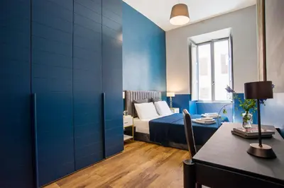a bedroom with blue walls and a bed and a table at La Trasteverina apartment in Rome