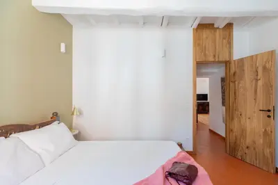 a bedroom with a white bed and a wooden door at iFlat Peaceful brand new 2beds apt in Trastevere in Rome