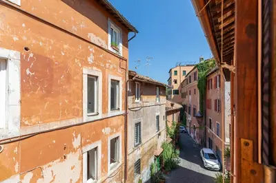 an alley between two buildings with a car parked on the street at iFlat Peaceful brand new 2beds apt in Trastevere in Rome